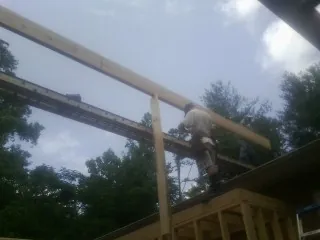 Carpenter setting a ridge beam over a new addition frame — Ice Dam Removal by Roofing Brothers in Selden