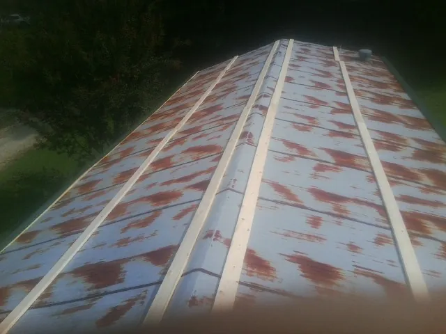 Rusted metal roof panels with new wood purlins before replacement — Storm Damage Roof Repair in Selden by Roofing Brothers