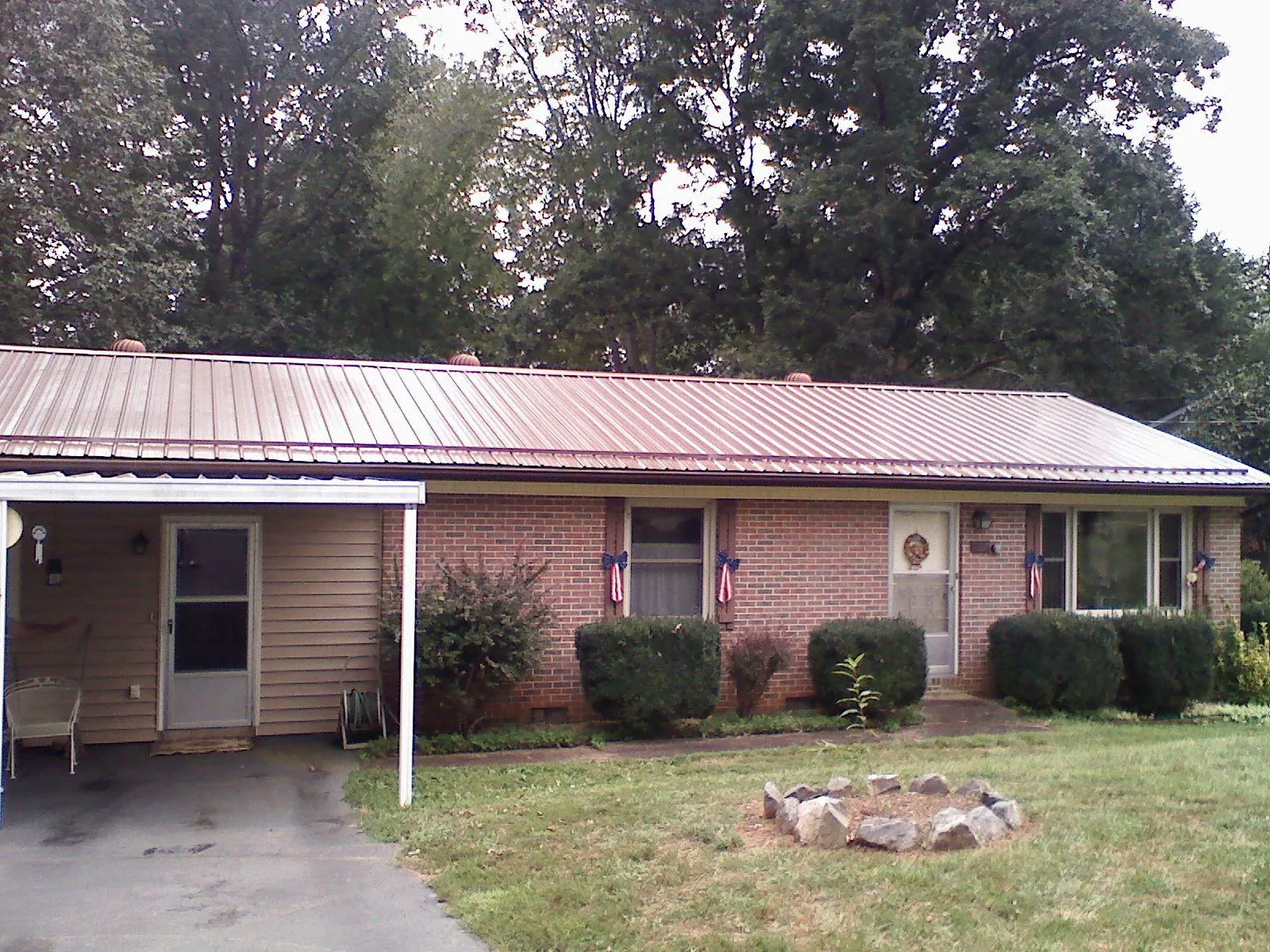 Bronze metal roof and carport on a brick ranch home — Roof Repair work by our crew in Selden