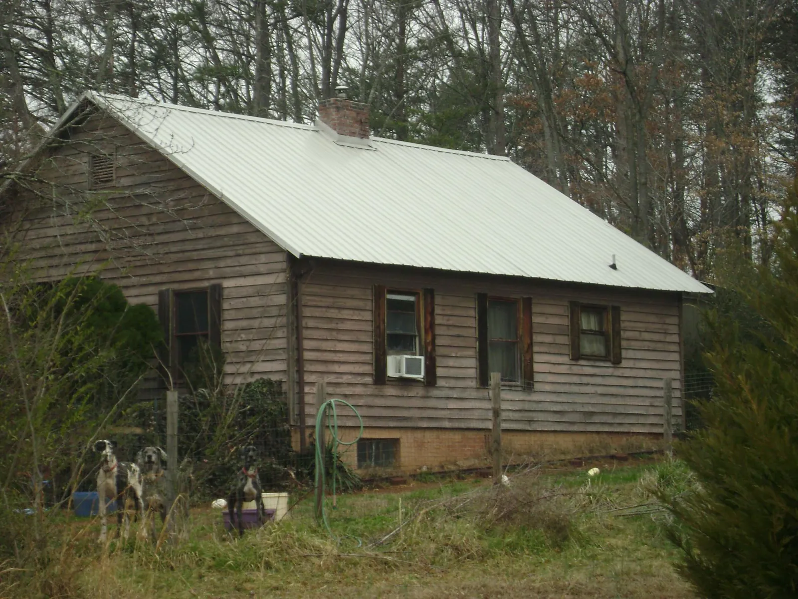 White metal roof on an old wood sided farmhouse, from a Metal Roof Installation job in Selden